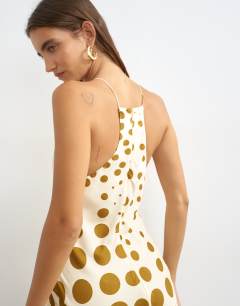 Model wearing Cut away racer neck full skirt maxi dress in taupe and chocolate polka dot