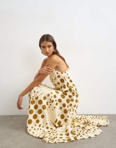 Model wearing Cut away racer neck full skirt maxi dress in taupe and chocolate polka dot