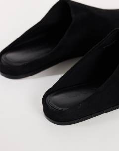 Model wearing Debbie faux suede square toe flat shoe mule in black