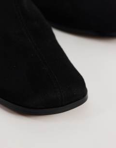 Model wearing Debbie faux suede square toe flat shoe mule in black