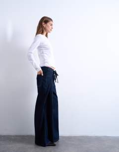 Model wearing Deep pleated tie front jean in indigo