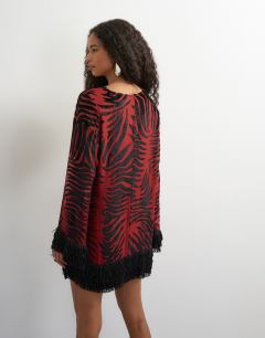 Model wearing Deep v mini wrap mini dress in red devore zebra with embellished fringed hem