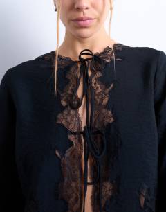Model wearing Delicate tie front long sleeve top with lace in black
