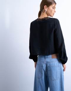 Model wearing Delicate tie front long sleeve top with lace in black