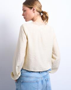 Model wearing Delicate tie front long sleeve top with lace in oyster