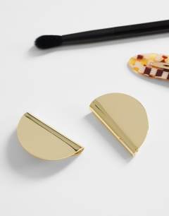 Model wearing Della statement stud earrings in gold