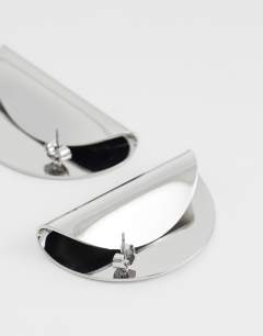 Model wearing Della statement stud earrings in silver