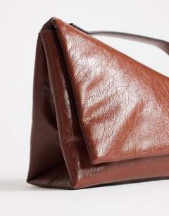 Model wearing Delta medium pyramid top handle grab bag in tan