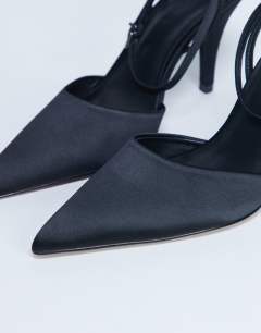 Model wearing Demi cone heel court shoe with tie in black