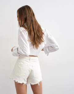 Model wearing Denim A-line short with rip in white