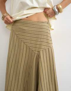 Model wearing Denim asymmetric drop waist maxi skirt in khaki stripe