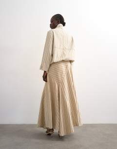 Model wearing Denim asymmetric dropped waist maxi skirt in ecru stripe