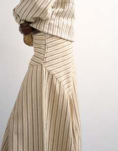 Model wearing Denim asymmetric dropped waist maxi skirt in ecru stripe