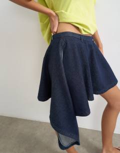 Model wearing Denim asymmetric mini skirt in rinse wash