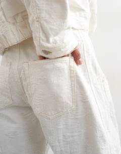 Model wearing Denim barrel jort in distressed ecru
