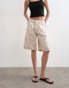 Model wearing Denim barrel jort in ecru jacquard floral