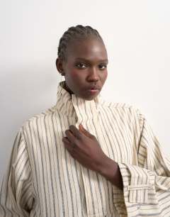 Model wearing Denim bubble hem top with funnel neck in ecru stripe