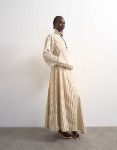 Model wearing Denim bubble hem top with funnel neck in ecru stripe