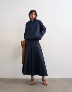 Model wearing Denim bubble hem top with funnel neck in indigo rinse