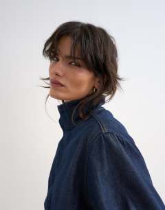 Model wearing Denim bubble hem top with funnel neck in indigo rinse