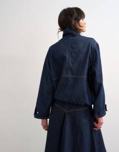 Model wearing Denim bubble hem top with funnel neck in indigo rinse
