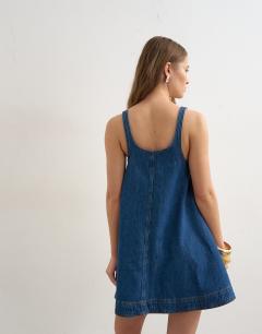 Model wearing Denim circle pinny dress in rich blue