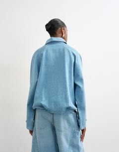 Model wearing Denim collared quarter zip blouson jacket in mid blue