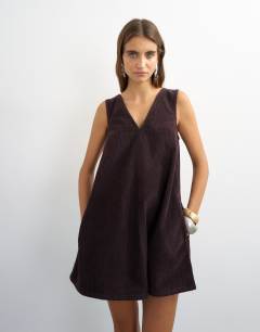 Model wearing Denim cord pinny v neck mini dress in chocolate