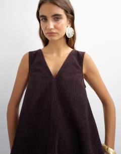Model wearing Denim cord pinny v neck mini dress in chocolate