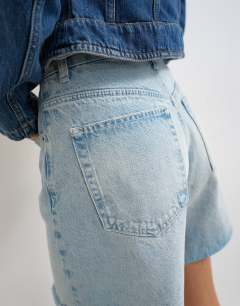Model wearing Denim distressed Editor short in bleach