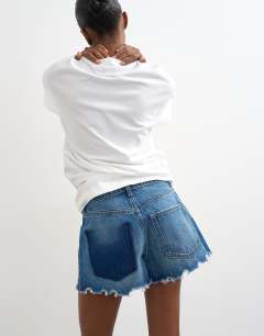 Model wearing Denim distressed split a-line short in rich blue