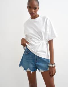 Model wearing Denim distressed split a-line short in rich blue