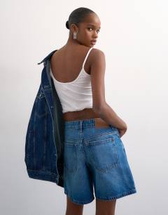 Model wearing Denim Editor short in mid blue