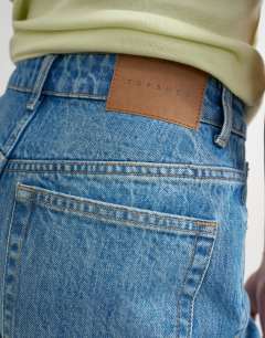 Model wearing Denim Editor short in mid blue