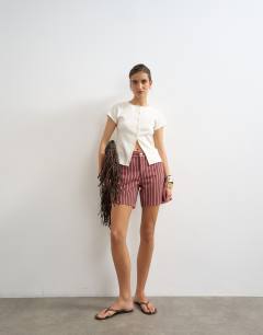 Model wearing Denim Editor short in red and pink stripe