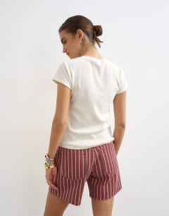 Model wearing Denim Editor short in red and pink stripe