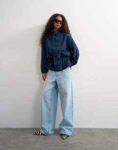 Model wearing Denim elasticated waist funnel sporty track jacket in indigo
