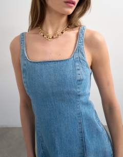 Model wearing Denim flippy seamed pleat hem mini dress in bleach