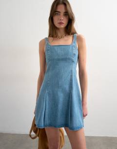 Model wearing Denim flippy seamed pleat hem mini dress in bleach