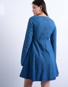 Model wearing Denim flute sleeve mini dress in mid blue