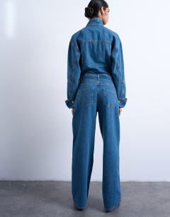 Model wearing Denim funnel neck belted jumpsuit in mid blue