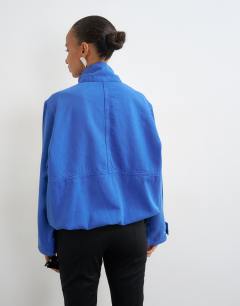 Model wearing Denim funnel neck bubble hem top in colbalt