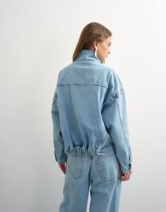 Model wearing Denim funnel neck elastic hem detail jacket in bleach