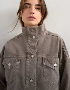 Model wearing Denim funnel neck elastic hem detail jacket stone