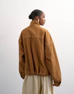 Model wearing Denim funnel neck elastic hem detail jacket tobacco