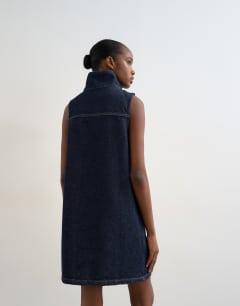 Model wearing Denim funnel neck pinny dress blue rinse