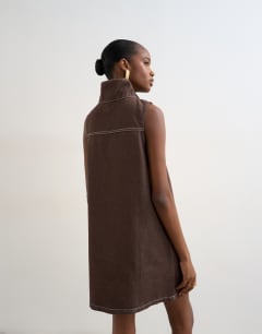 Model wearing Denim funnel neck pinny dress choc rinse