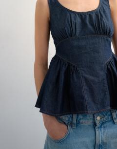 Model wearing Denim gather bust with peplum top in mid blue