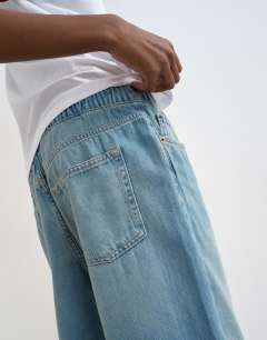 Model wearing Denim lightweight jogger jean in mid blue