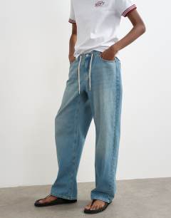 Model wearing Denim lightweight jogger jean in mid blue